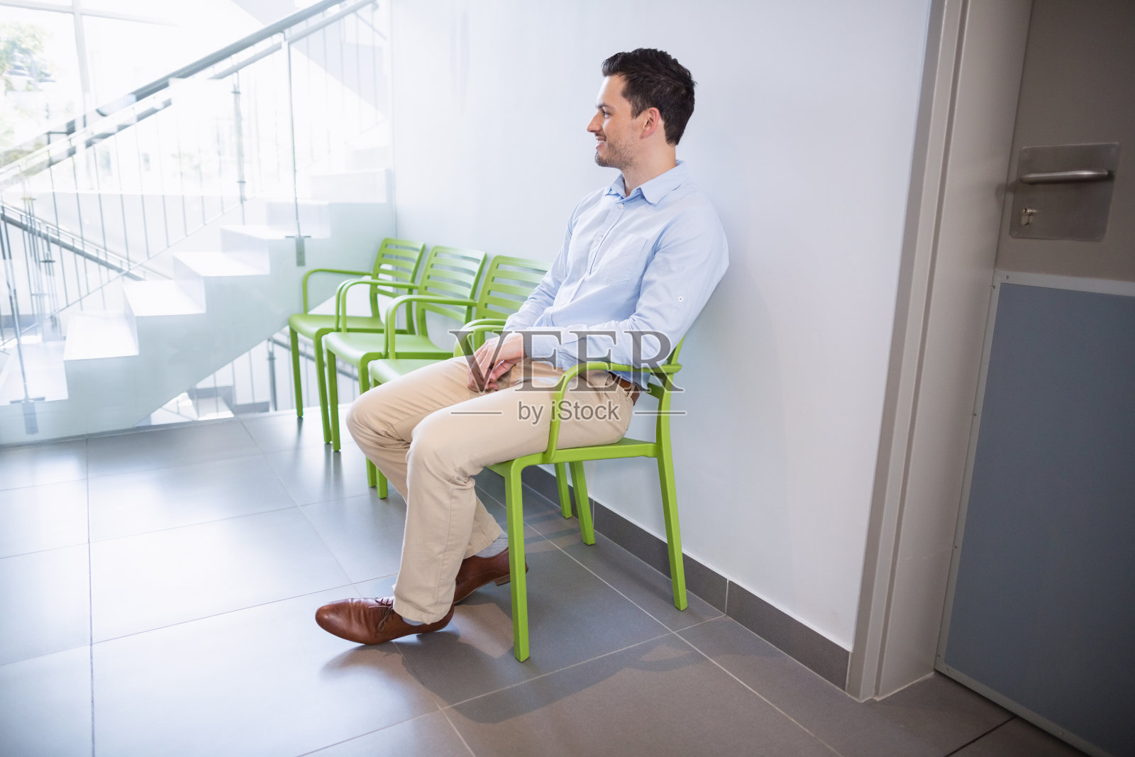 一个男人坐在医院走廊的椅子上照片摄影图片