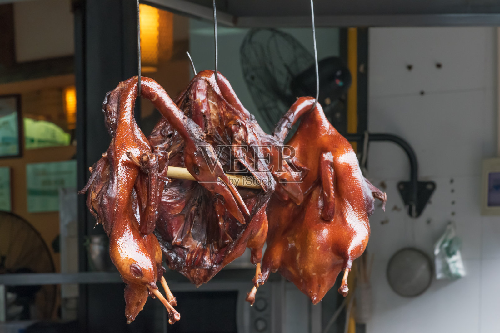 北京烤鸭挂在一家中餐馆的厨房里照片摄影图片