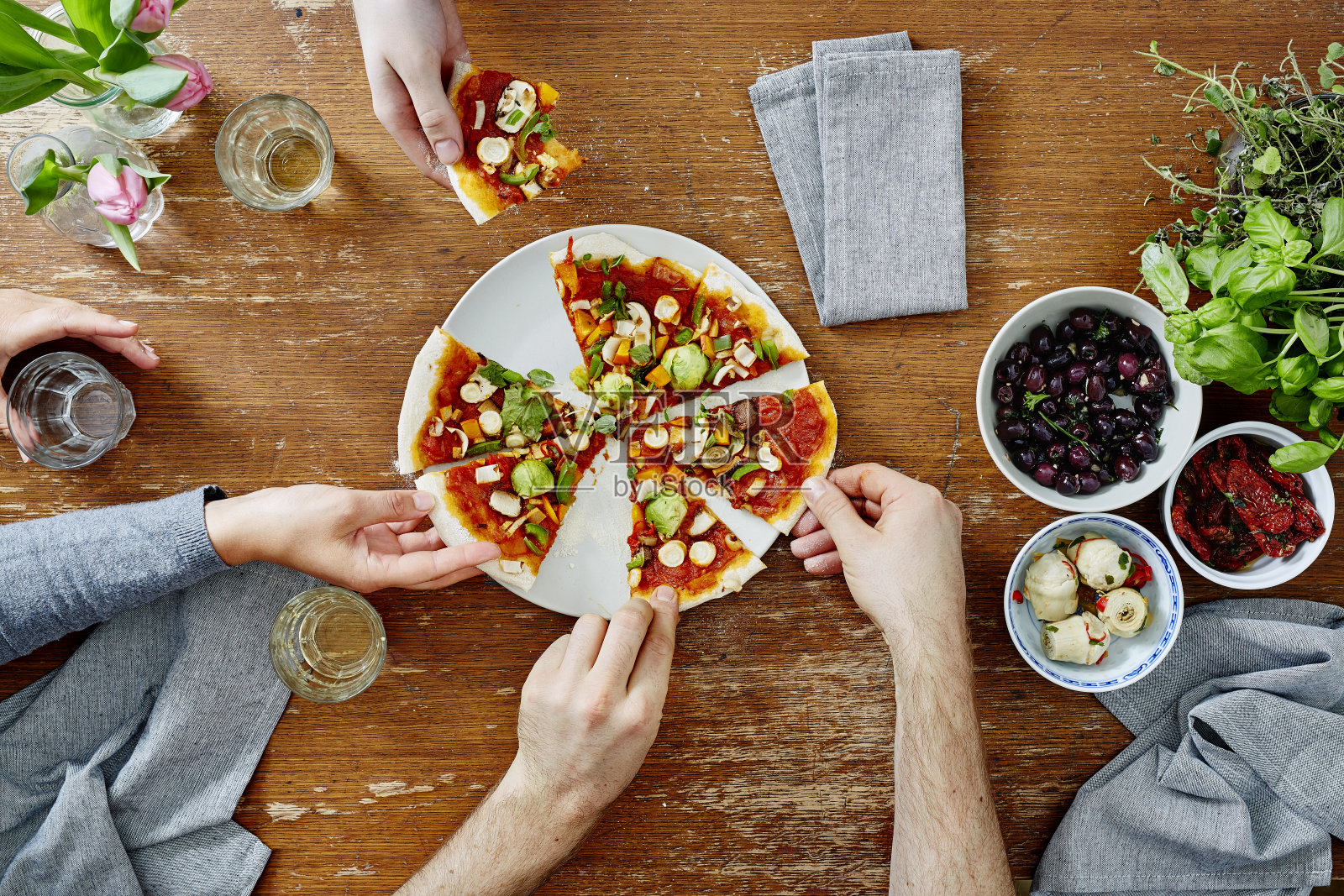 三个人在晚宴上分享有机美味的披萨照片摄影图片