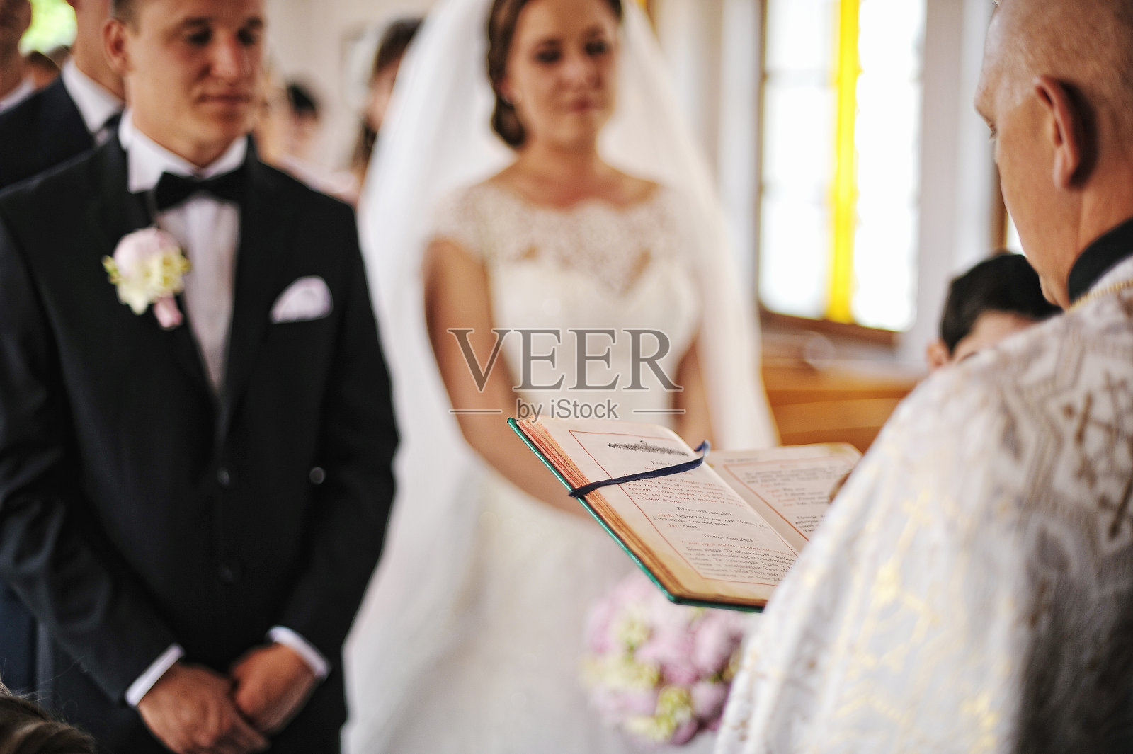 牧师为新婚夫妇读了一本圣经背景书照片摄影图片