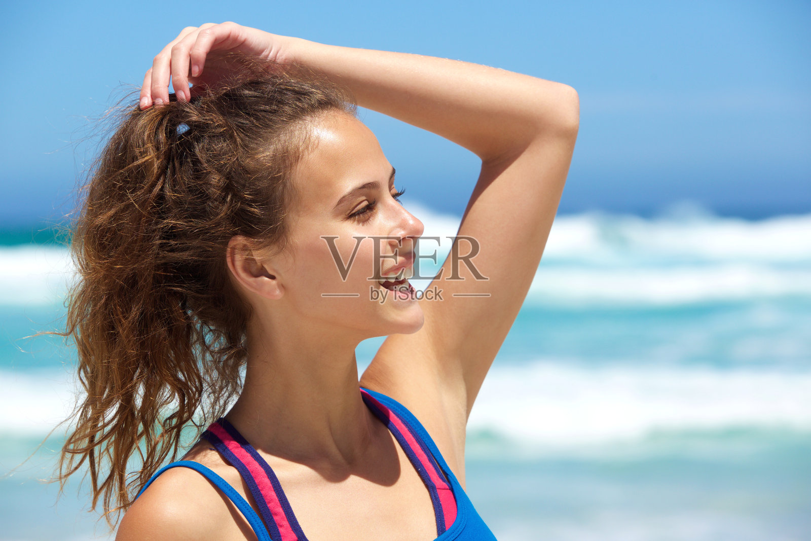 在海滩上微笑的年轻女子照片摄影图片