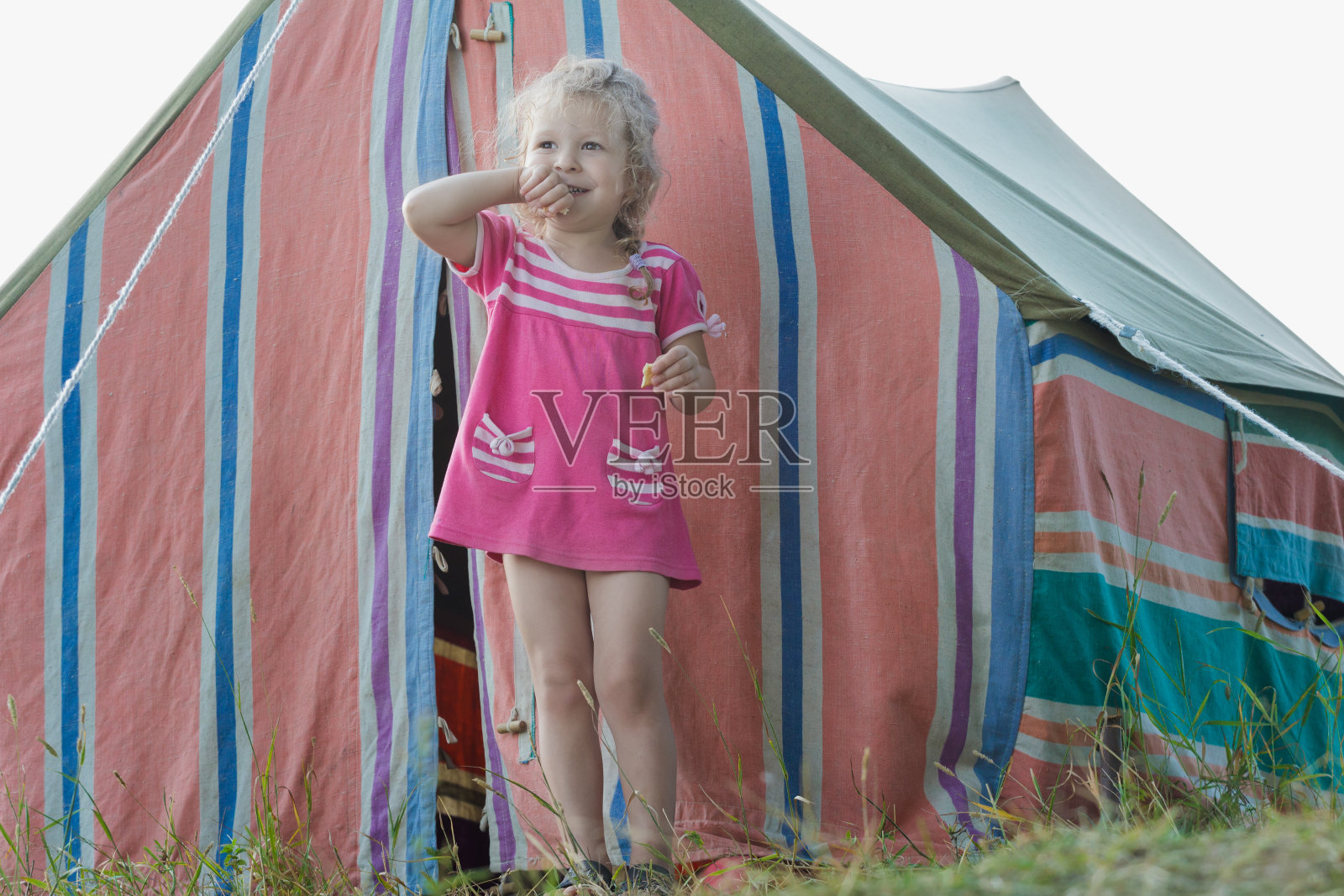 金发小露营女孩放松附近条纹复古帆布帐篷照片摄影图片
