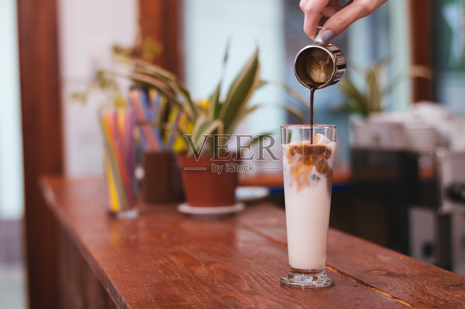 咖啡师的手制作拿铁或卡布奇诺咖啡倒牛奶照片摄影图片