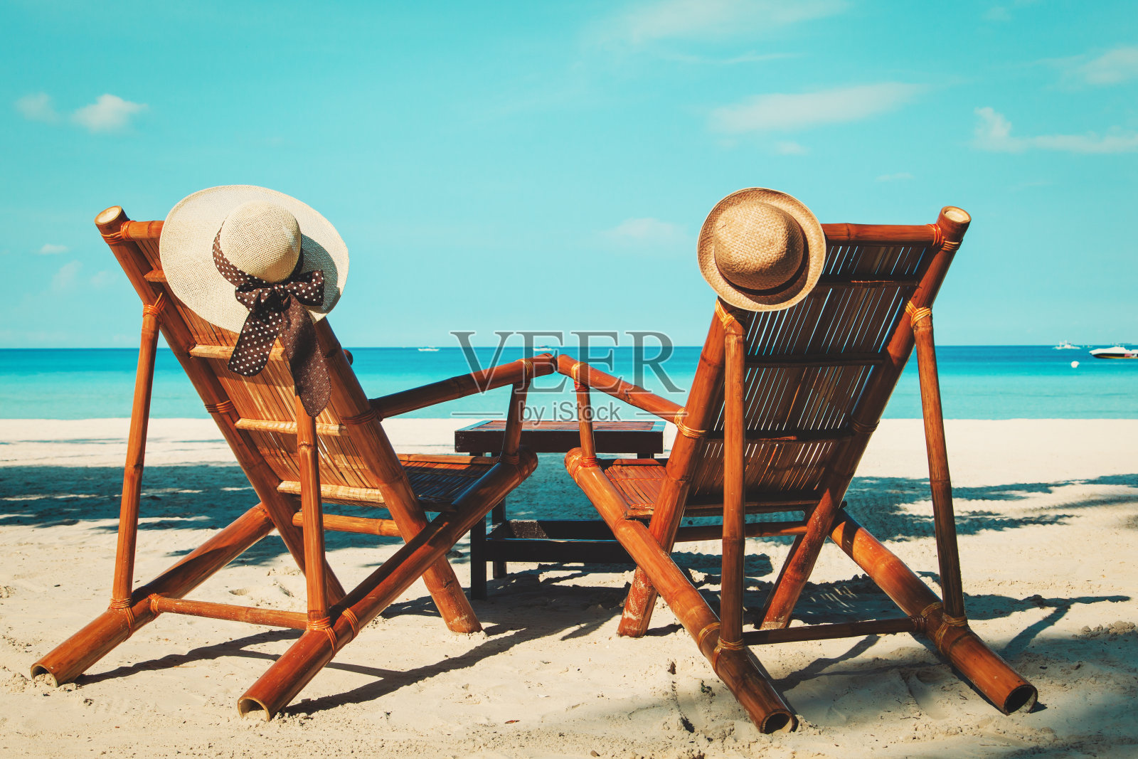 热带沙滩上的椅子上戴着帽子照片摄影图片