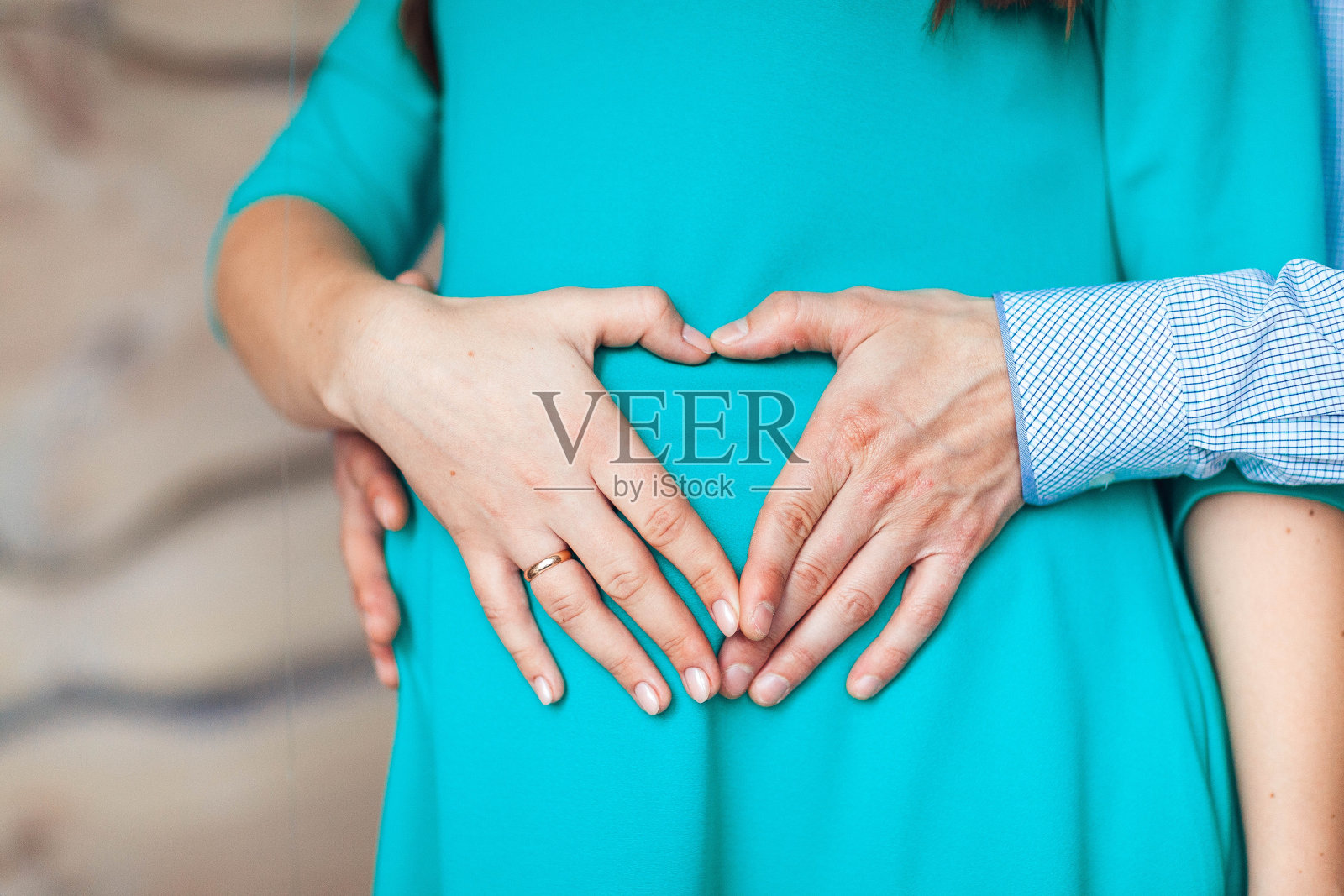 一对夫妇的手在妇女怀孕的肚子上做一个心形照片摄影图片