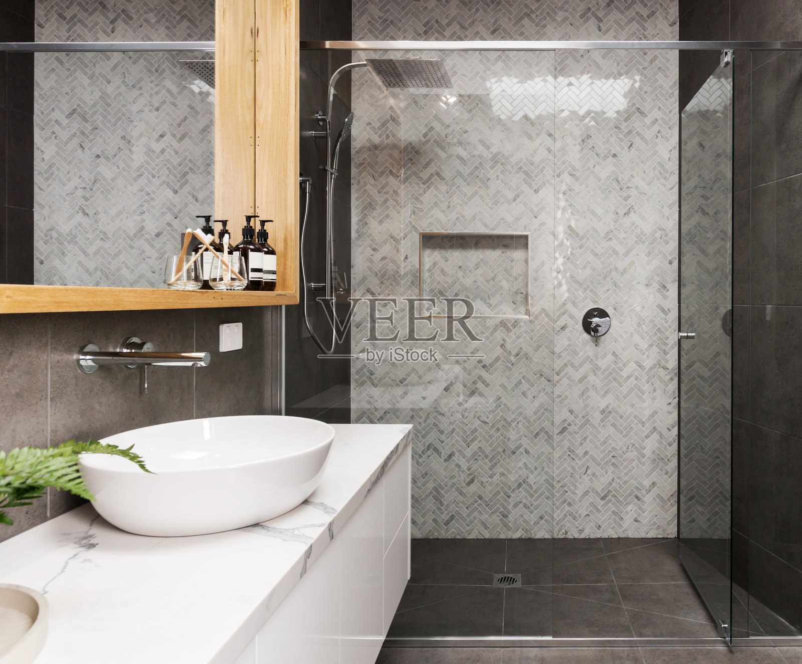 大理石马赛克人字形瓷砖淋浴功能墙在现代套间浴室照片摄影图片