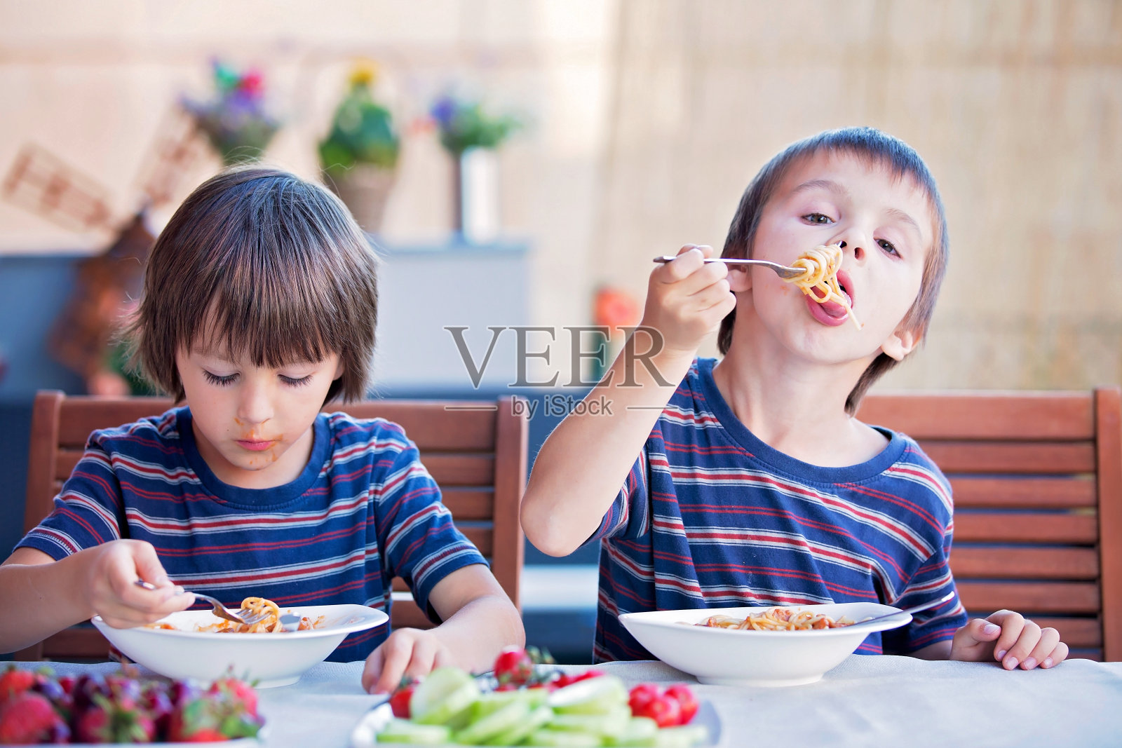 可爱的孩子，学前班的男孩，在户外吃意大利面当午餐照片摄影图片