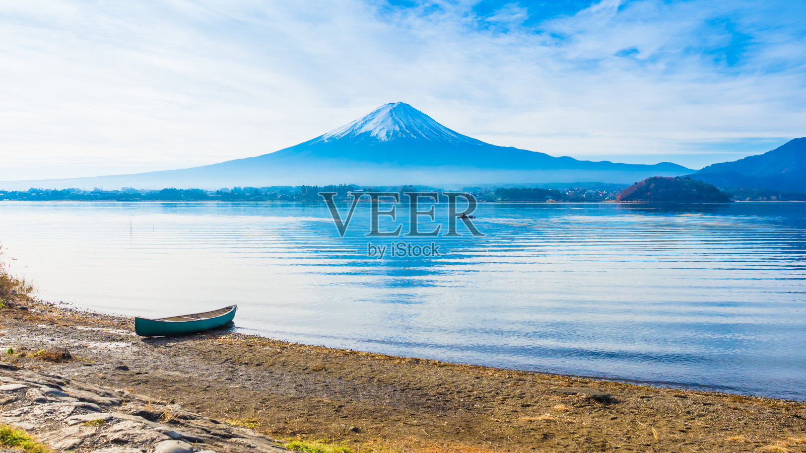 在富士山的背景下，一艘小船在清晨的川口湖岸边泊泊照片摄影图片