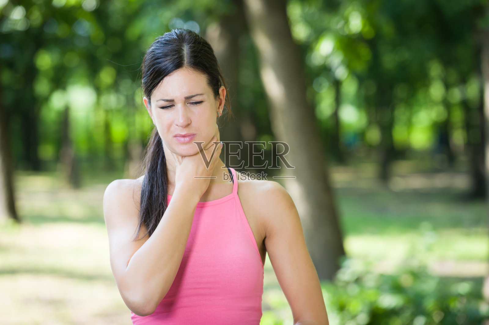 运动女性在公园里喉咙痛照片摄影图片