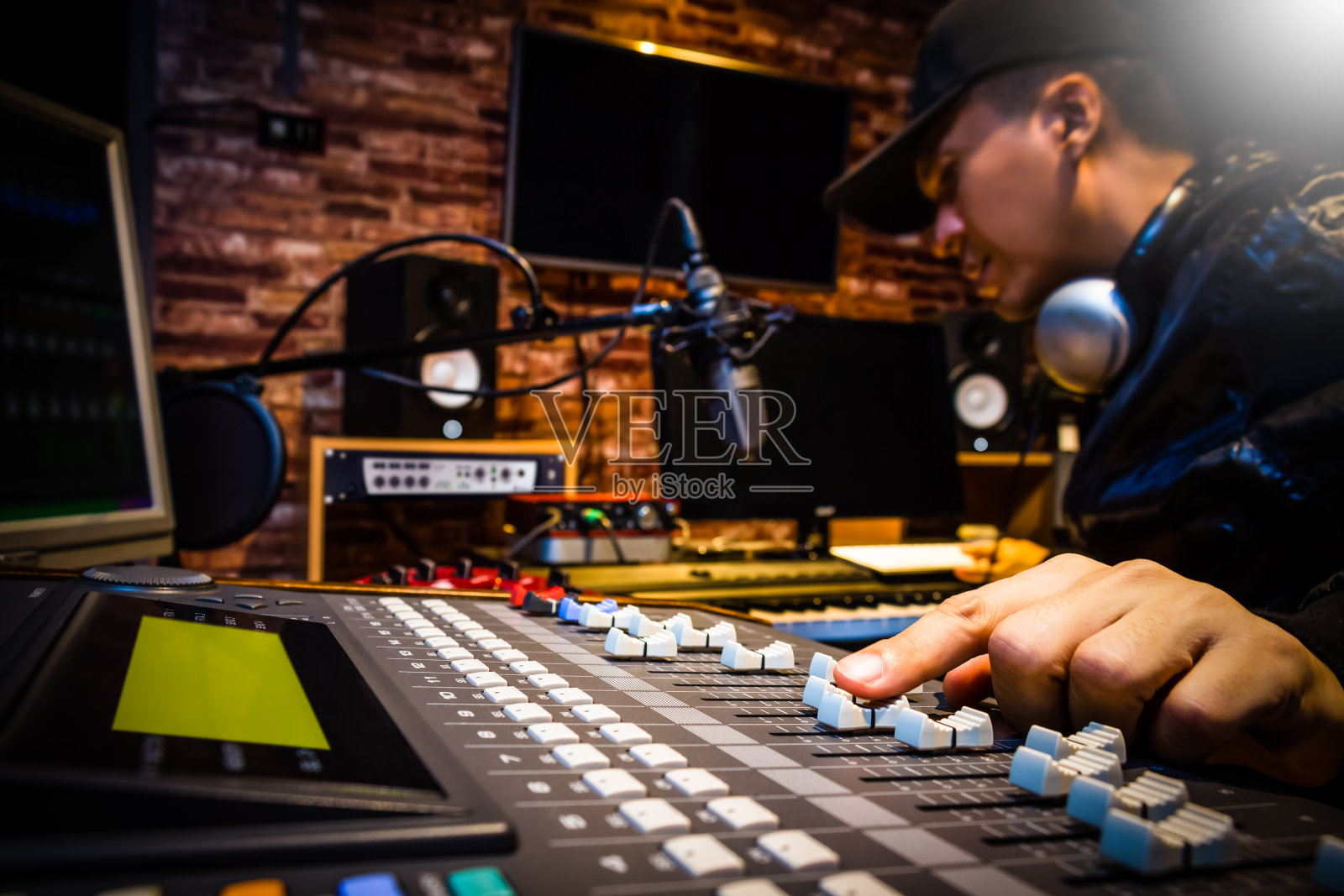 在录音室做混音的音乐制作人或在广播演播室做DJ照片摄影图片
