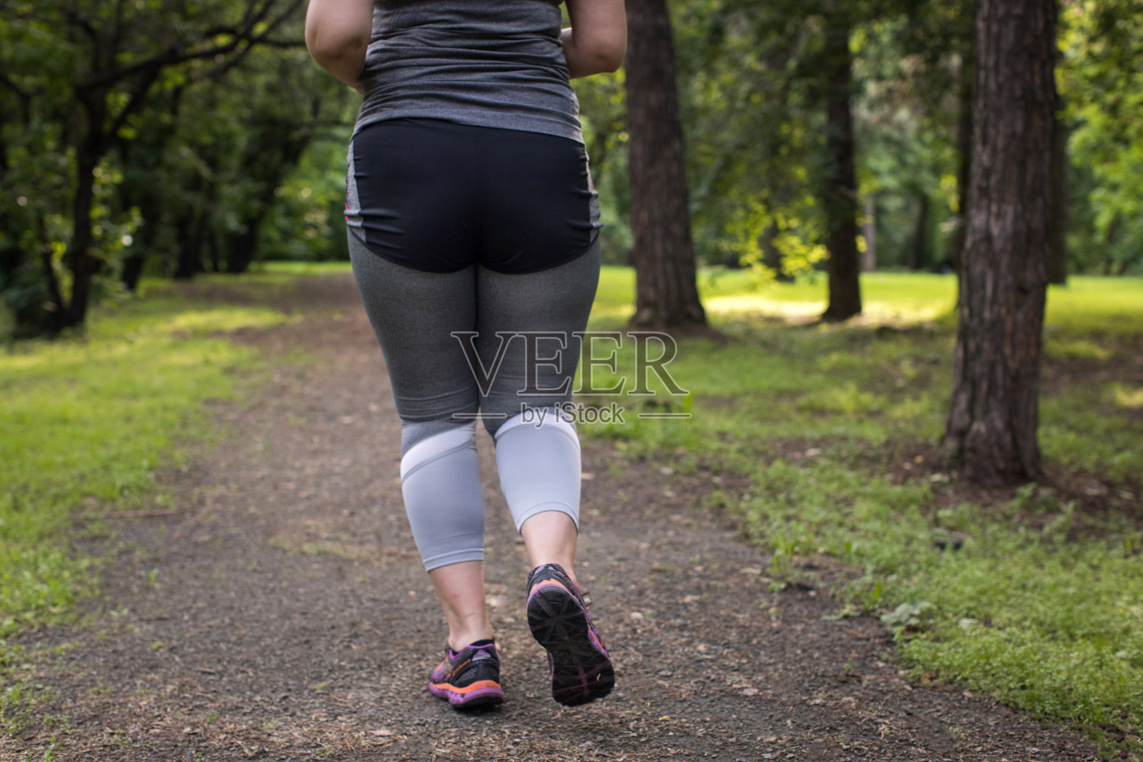 胖女人背跑。减肥的概念照片摄影图片