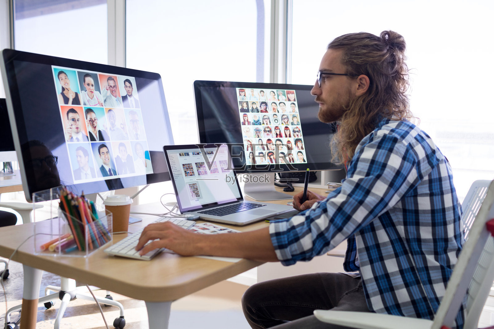 在办公桌上使用笔记本电脑和图形平板电脑工作的男性高管照片摄影图片
