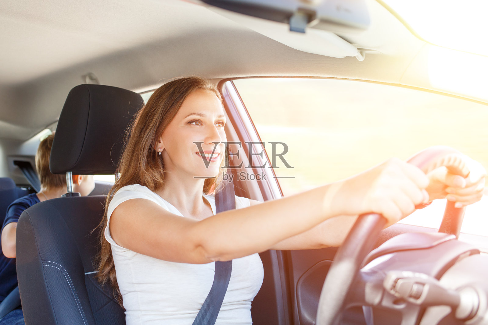微笑的年轻女子在夏天驾驶一辆汽车照片摄影图片