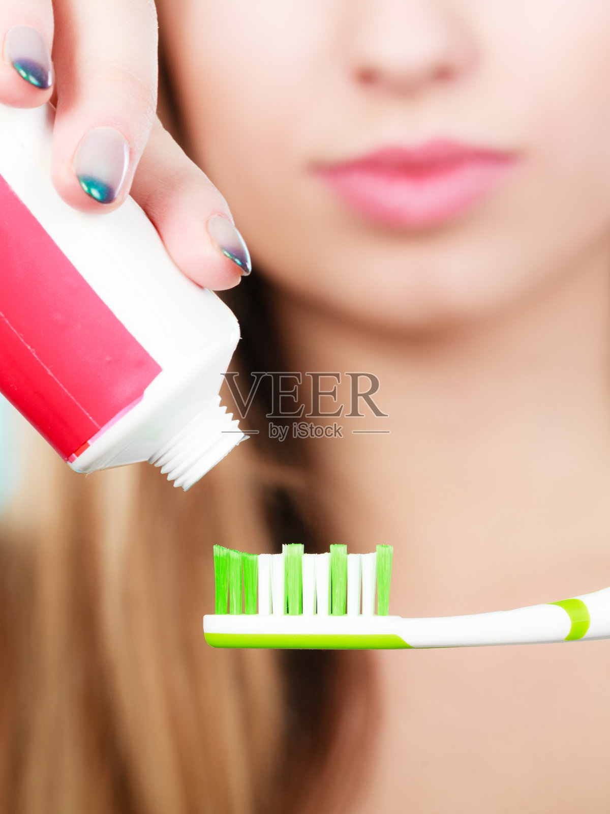 一个女人把牙膏涂在牙刷上照片摄影图片