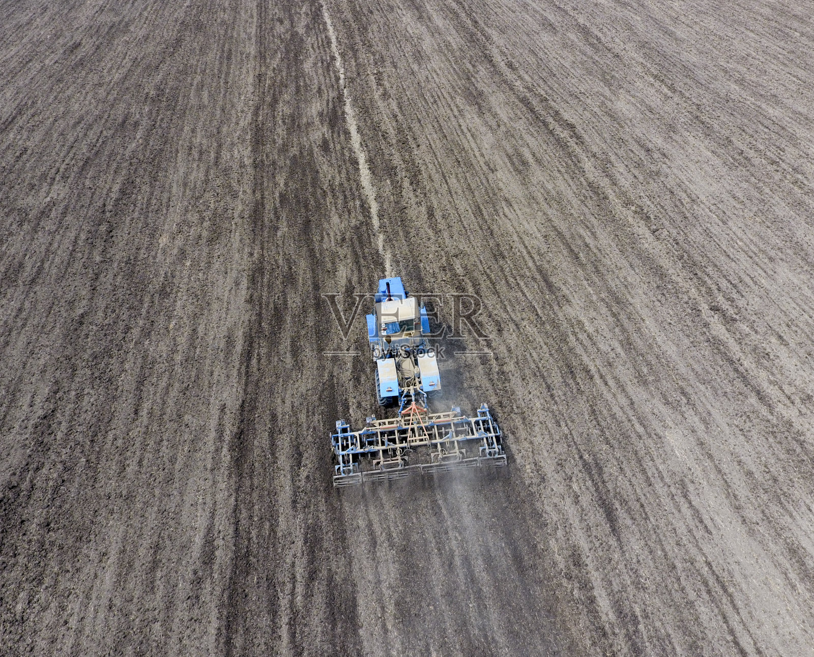 拖拉机犁地。播种时，田里的土壤要松。照片摄影图片