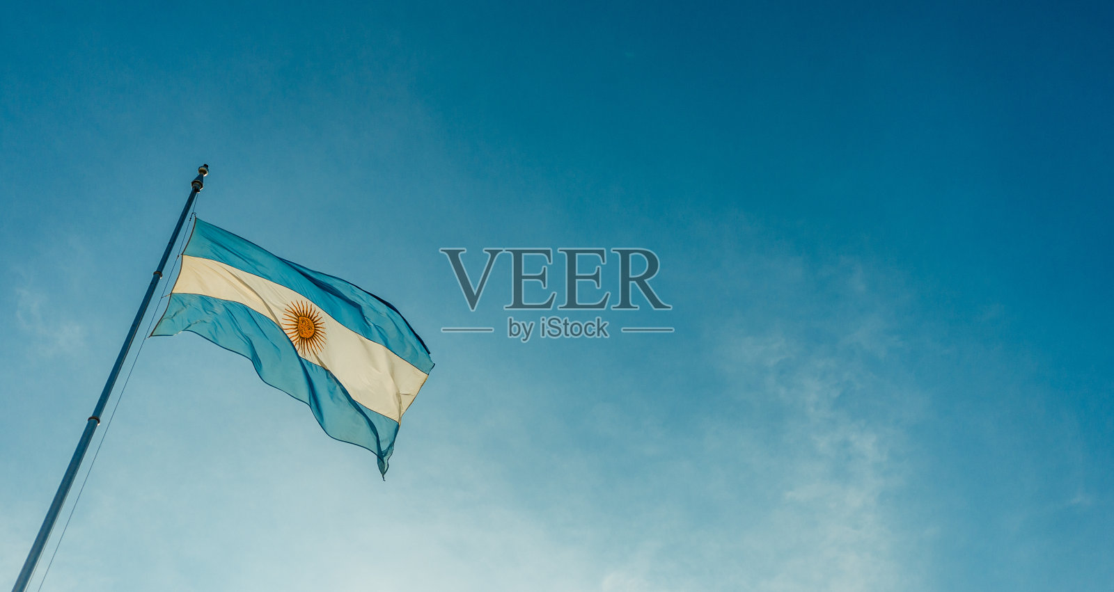 在晴朗的日子里，阿根廷国旗在蓝天下飘扬照片摄影图片
