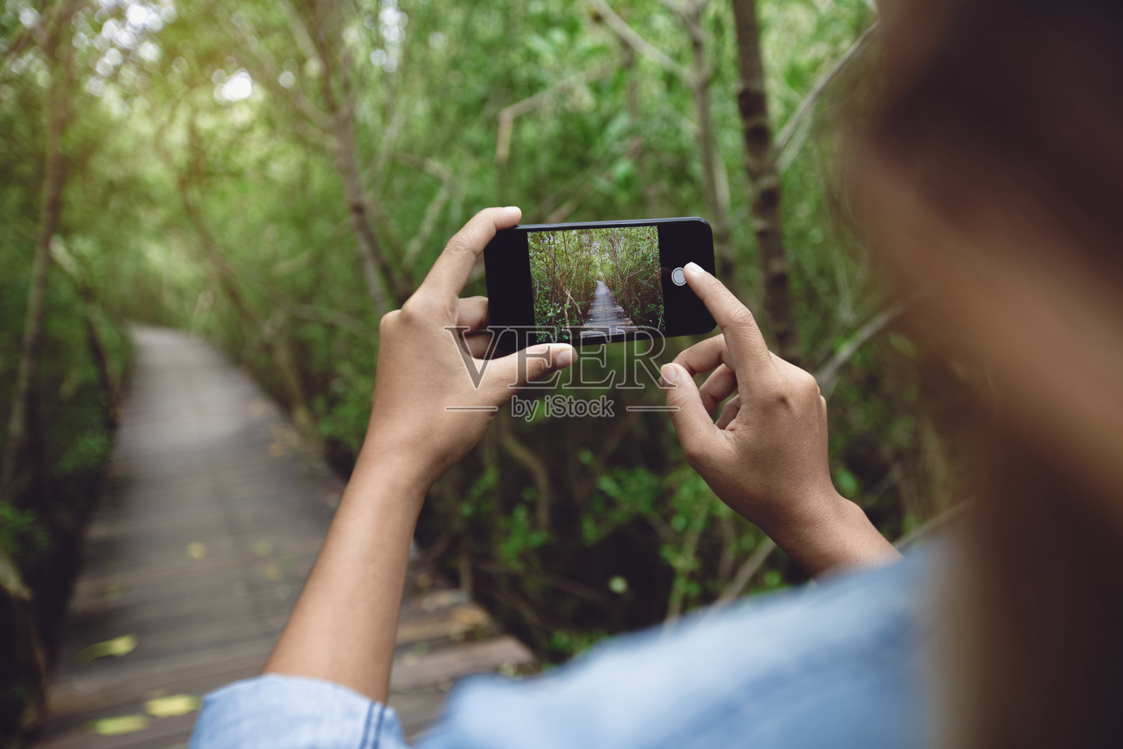女人用手机拍自然照片照片摄影图片