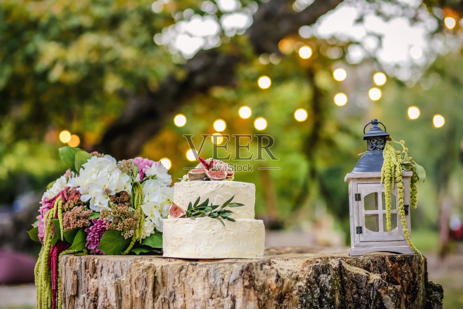 美丽的婚礼装饰蛋糕，花束和灯笼在自然的背景照片摄影图片