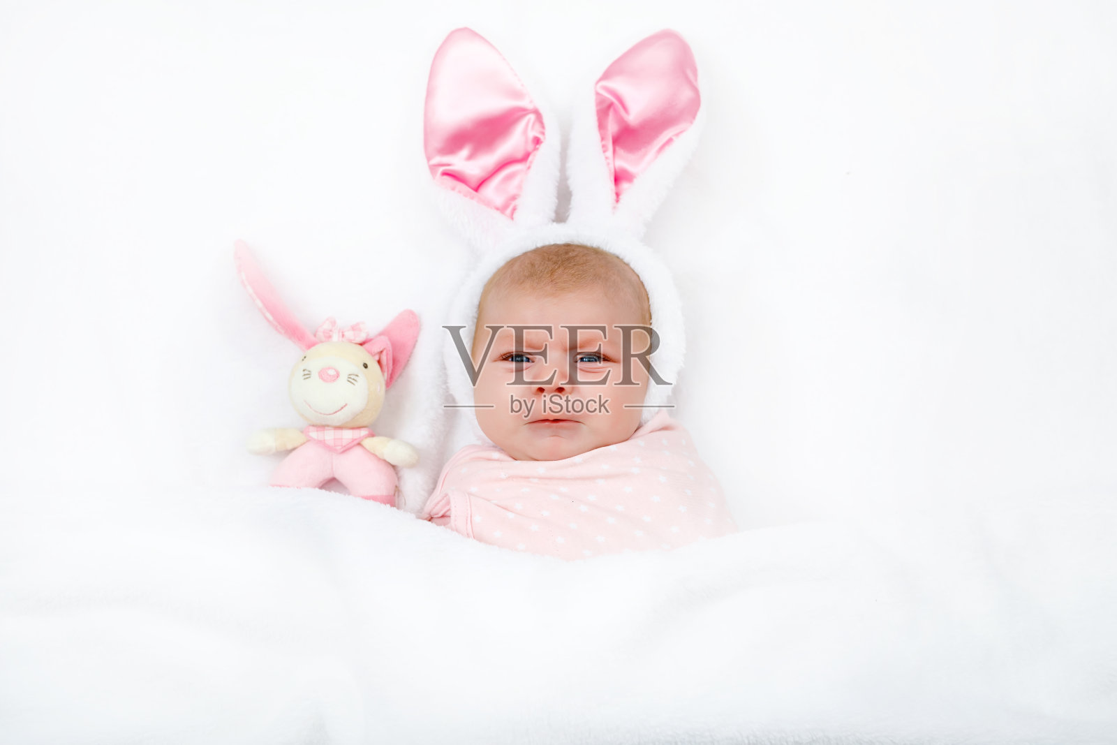 可爱可爱的新生女婴在复活节兔子服装和耳朵。照片摄影图片