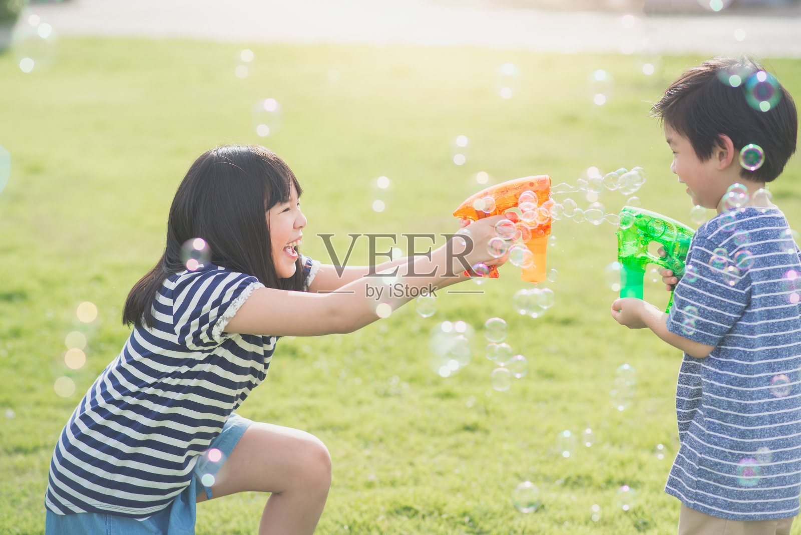 亚洲小孩用泡泡枪打泡泡照片摄影图片