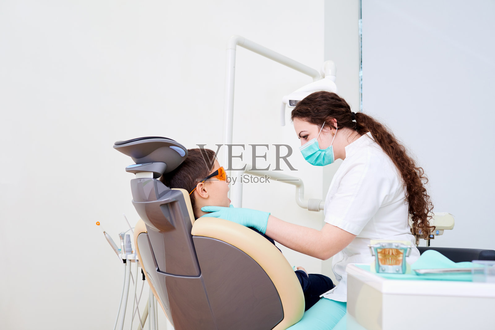 一个小孩在牙科诊所看牙医。牙科treatme照片摄影图片