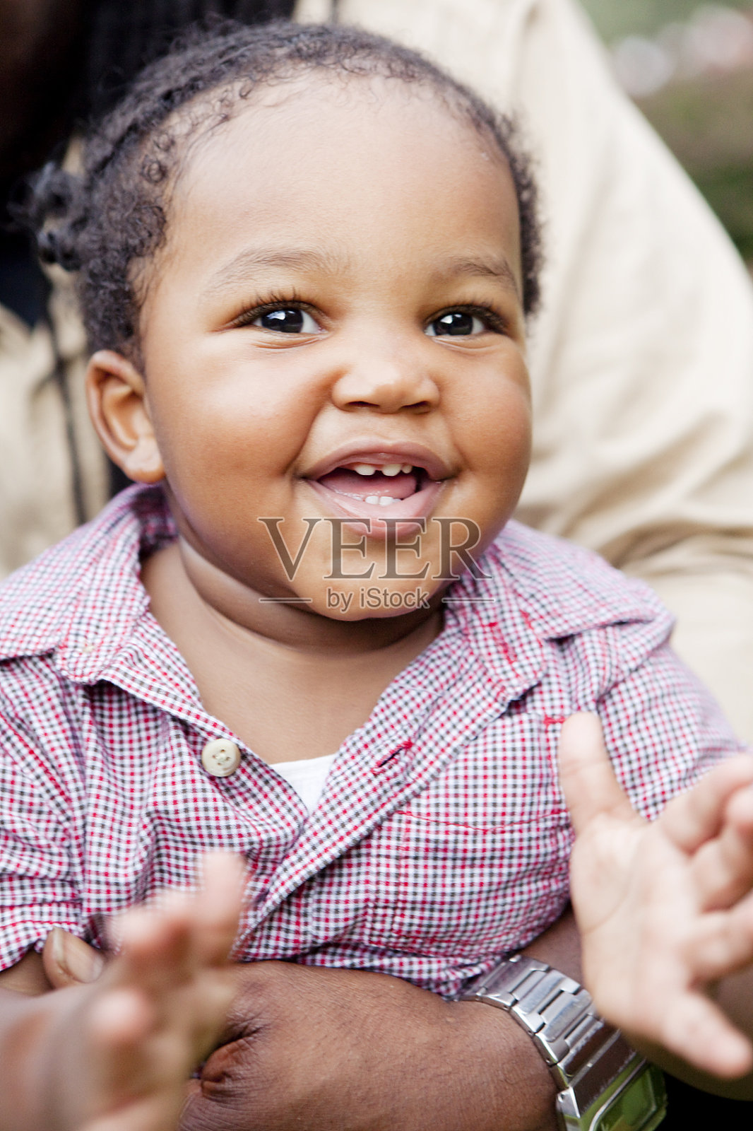 快乐的，微笑的黑婴儿拍着她的手照片摄影图片
