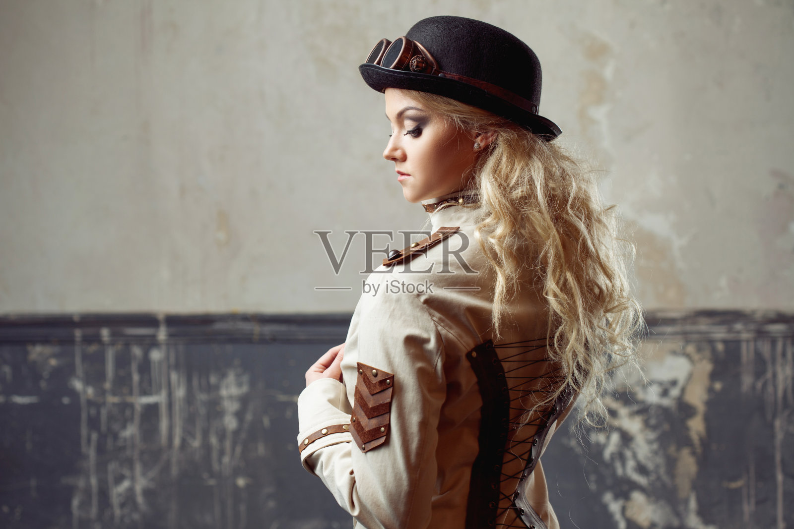 一个美丽的蒸汽朋克女人的肖像帽子圆顶礼帽在垃圾摇滚背景。照片摄影图片