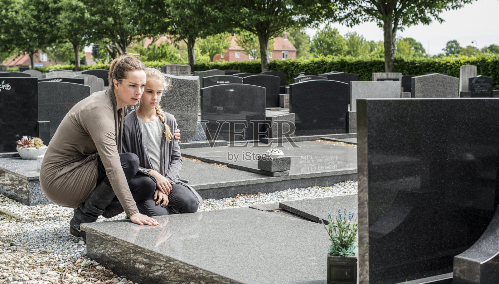 母亲和孩子参观墓地照片摄影图片