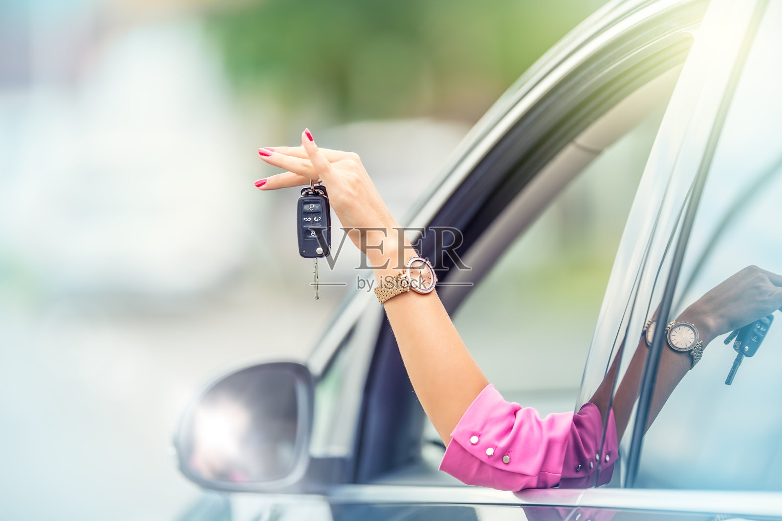 有魅力的女人伸出车窗，拿着车钥匙照片摄影图片