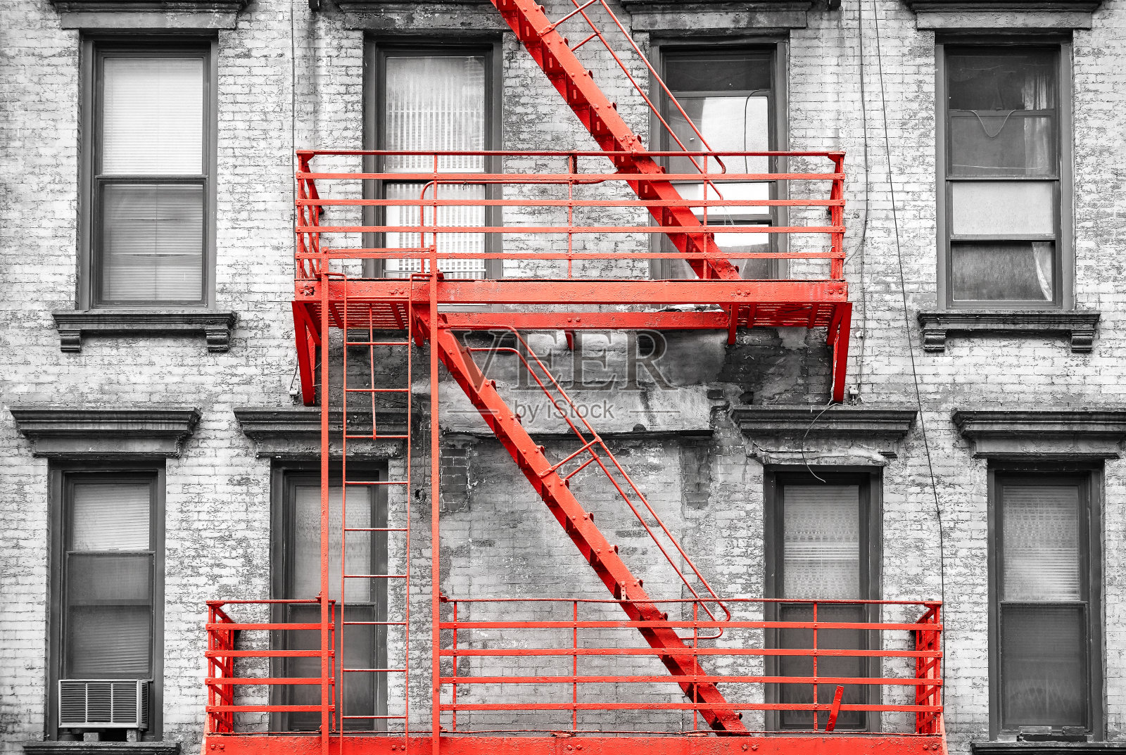 纽约市黑白过滤住宅楼的红色消防逃生梯。照片摄影图片