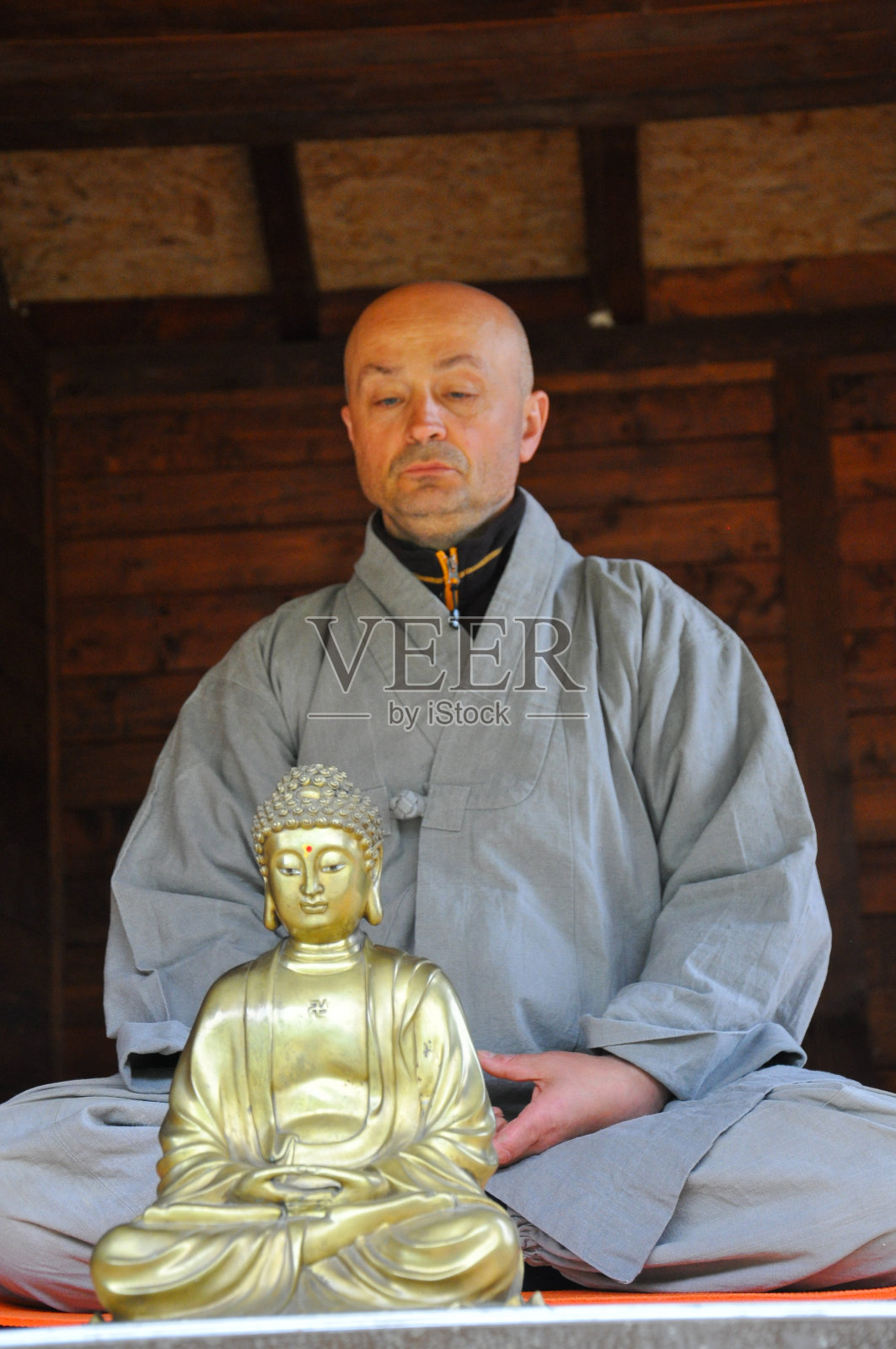 佛教冥想。一个老人在木屋里冥想。照片摄影图片