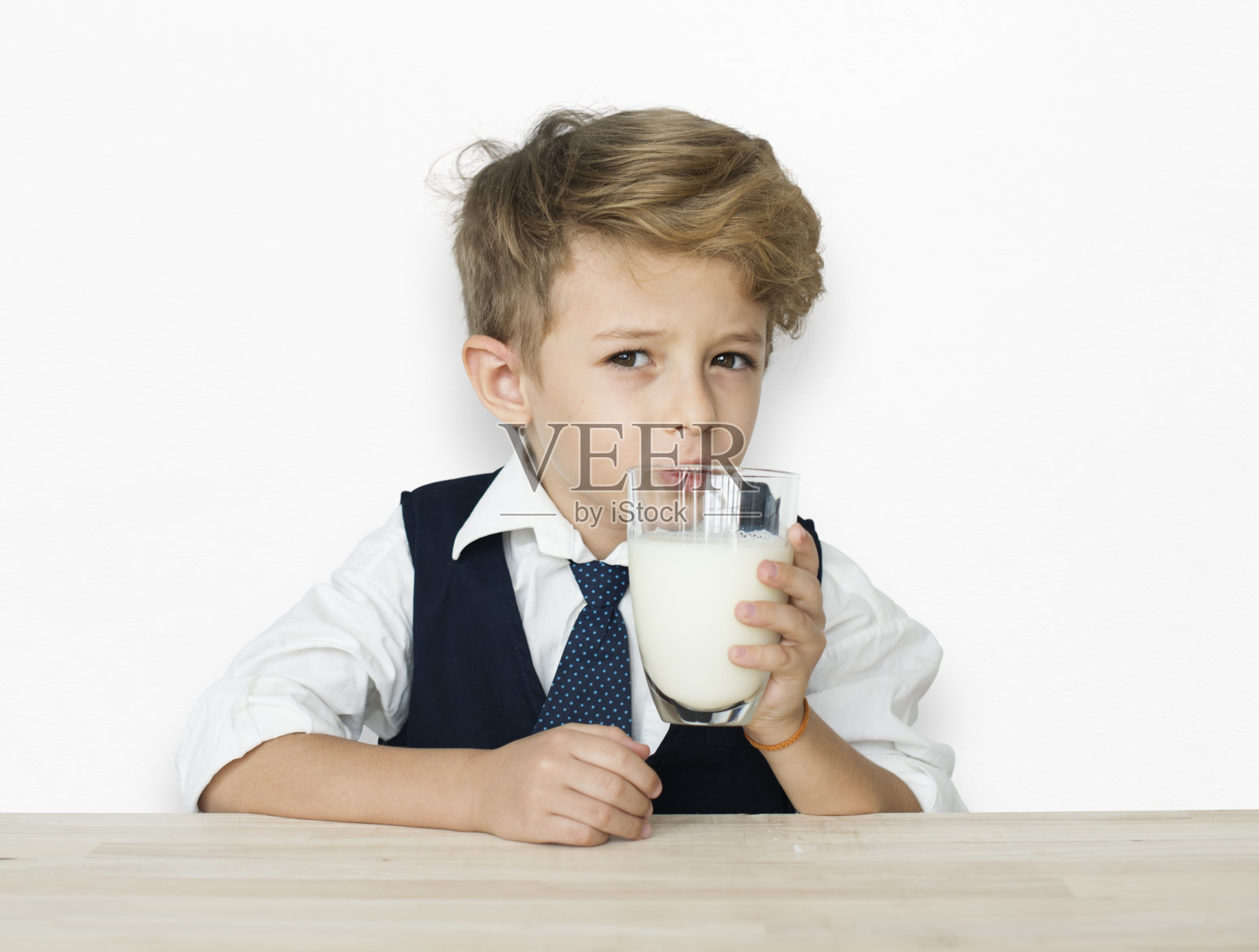 一个喝牛奶的白人男孩的背景画室肖像照片摄影图片