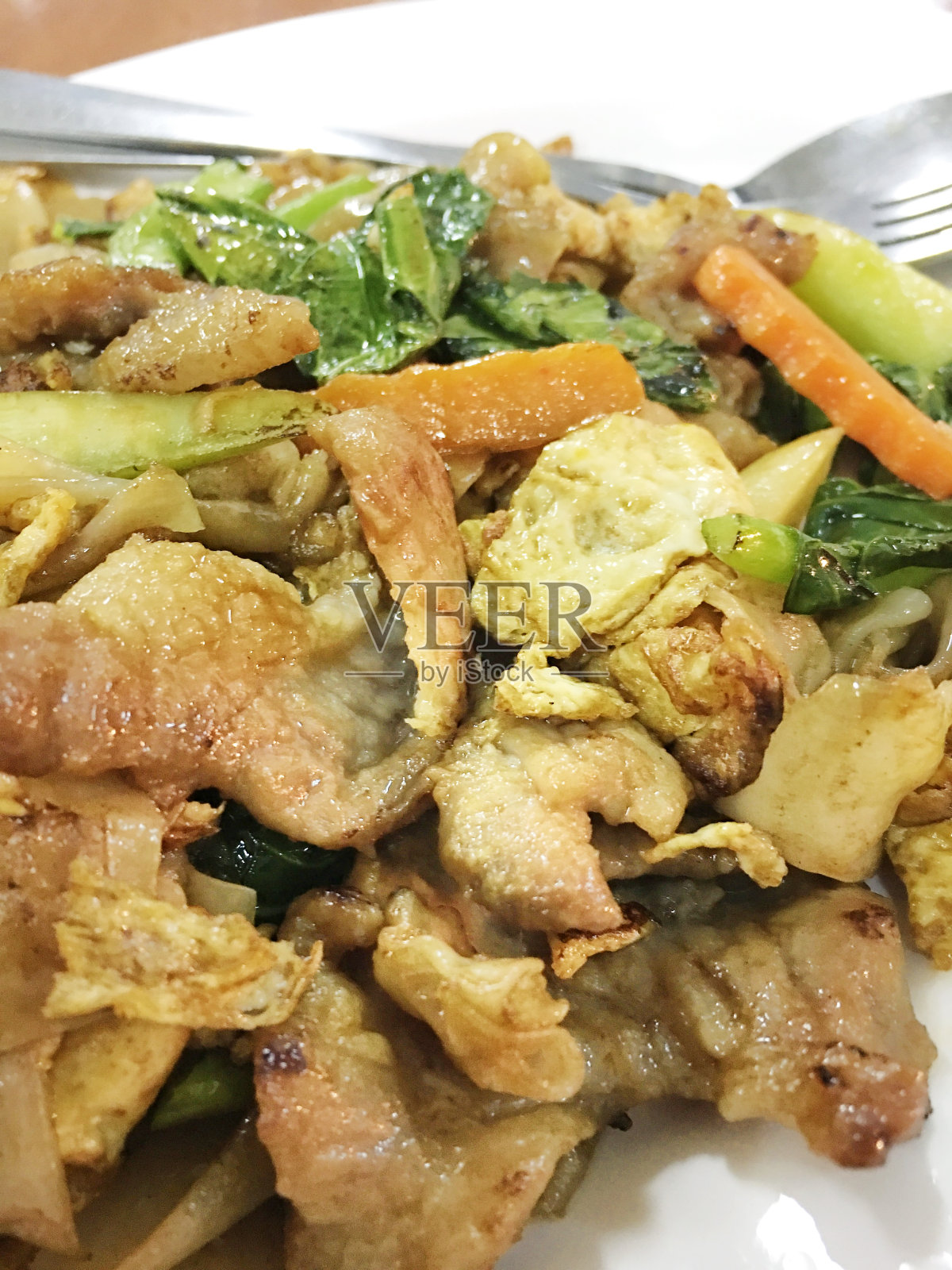 木桌上白底豆沙炒面和猪肉。泰国风格的食物。照片摄影图片