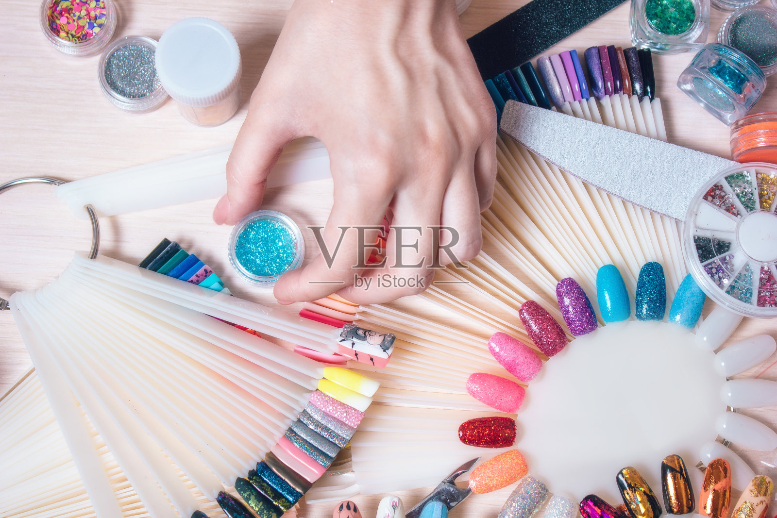 指甲艺术的概念。女人在白色桌子的钉子上做装饰照片摄影图片