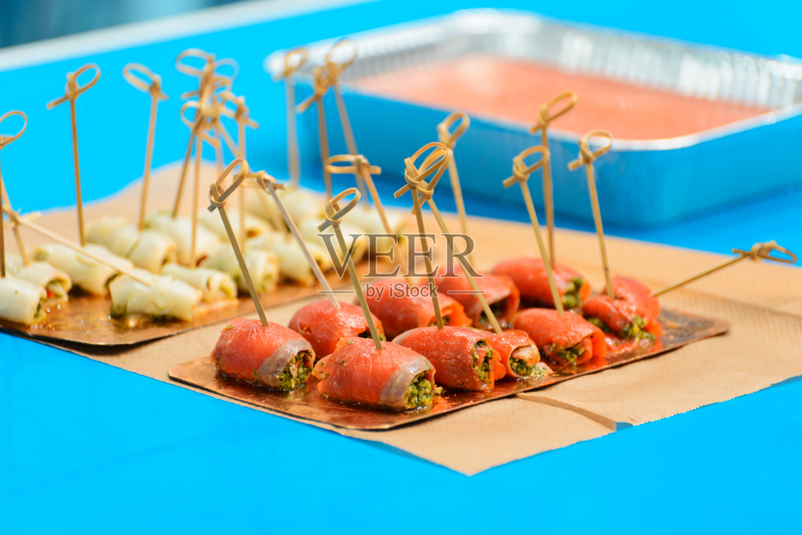 蓝色背景的竹签，菠菜和鲑鱼卷照片摄影图片