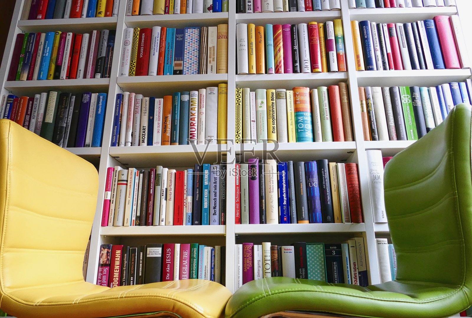 请坐:两张椅子前面的彩色图书馆书架照片摄影图片