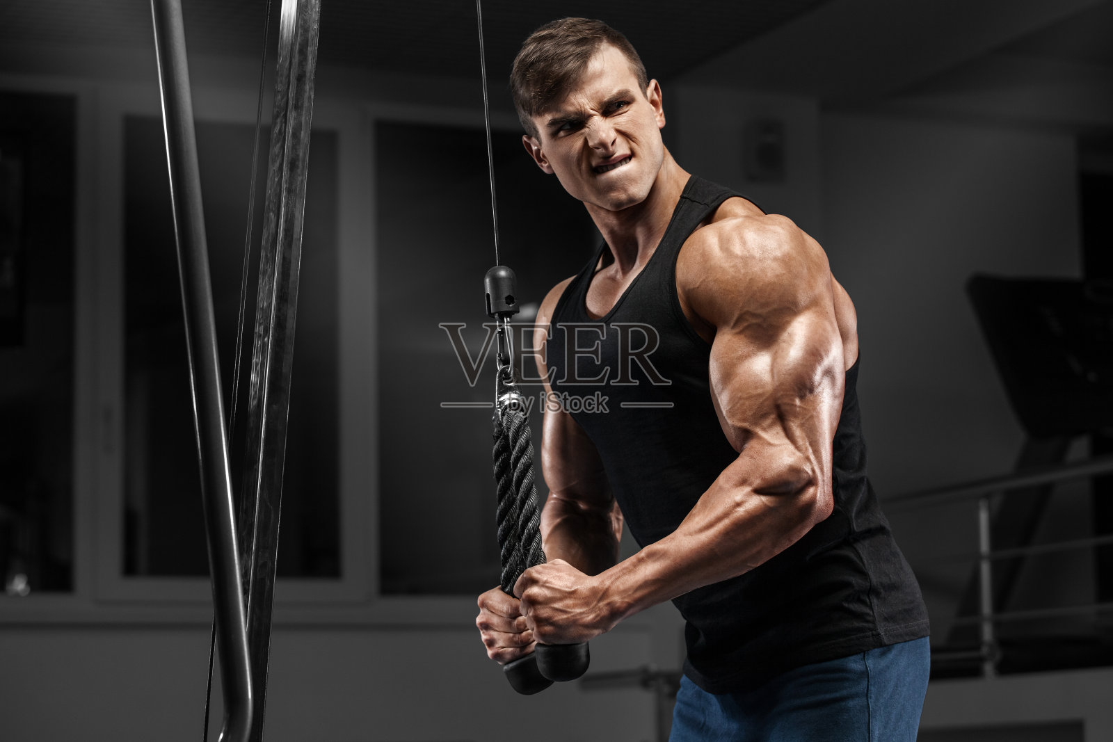 肌肉男在健身房锻炼三头肌，强壮的男性照片摄影图片