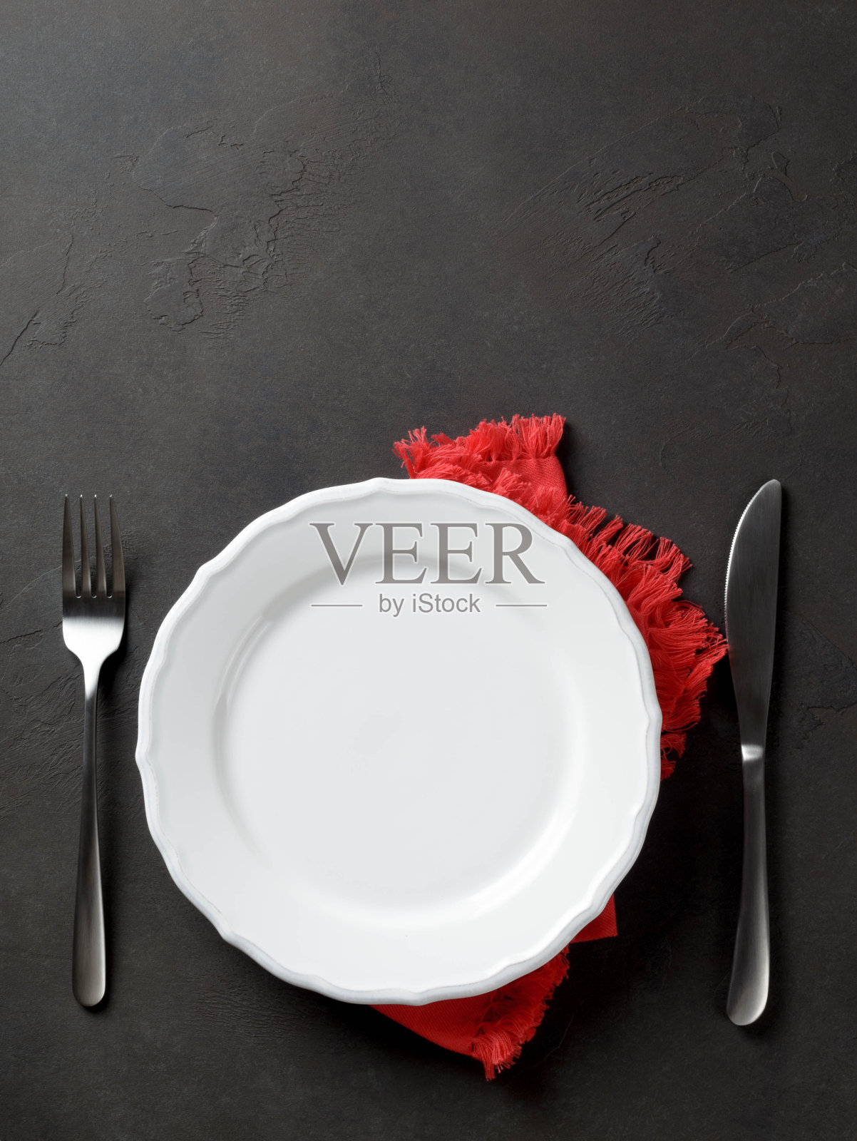 喜庆的刀叉套在白色盘子上，红餐巾上照片摄影图片