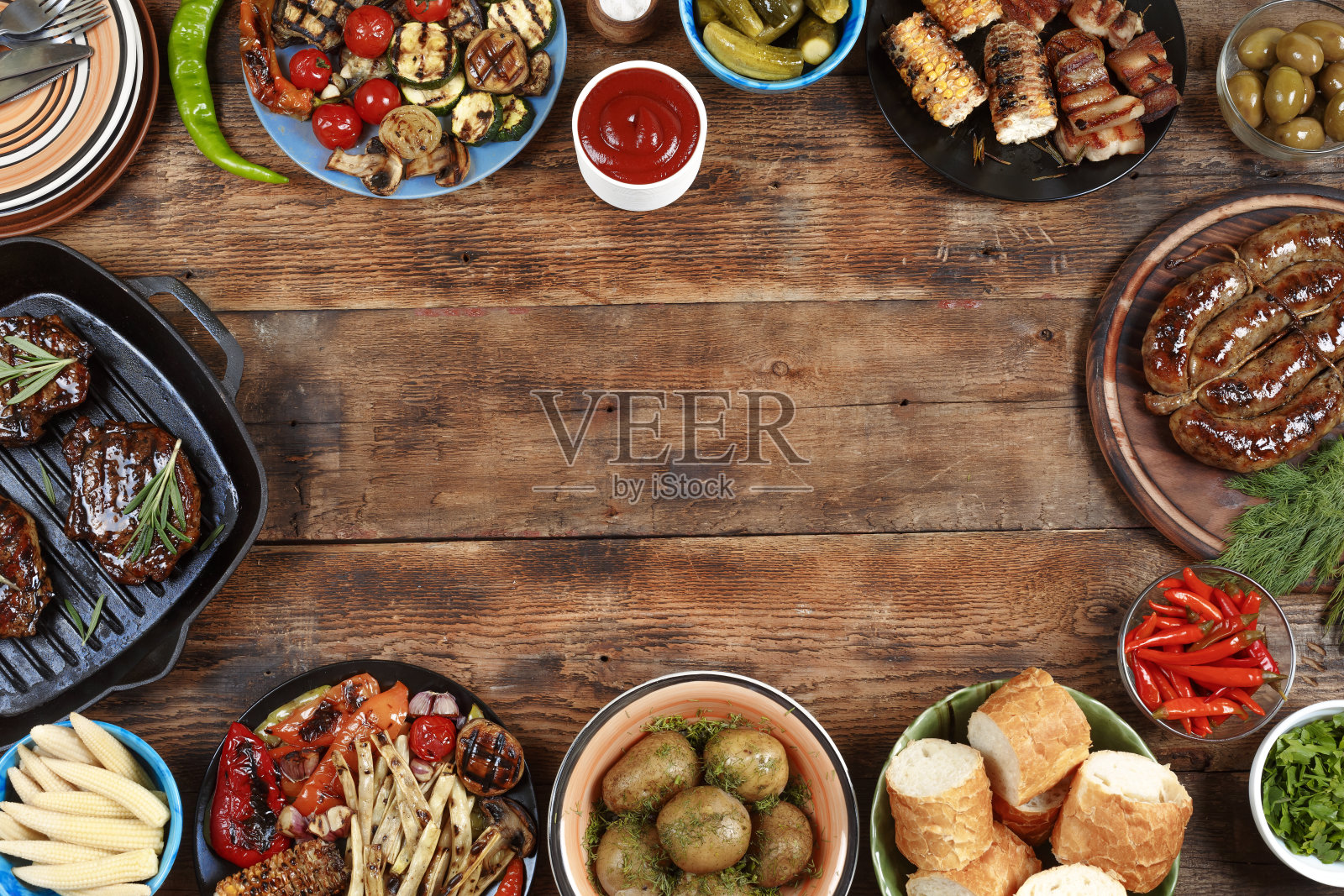 户外食品的概念。美味的烧烤牛排，香肠和烤蔬菜在一个木制的野餐桌上复印空间，俯视图照片摄影图片