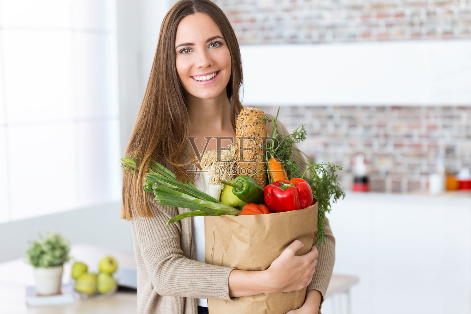 漂亮的年轻女人，家里装着蔬菜。照片摄影图片