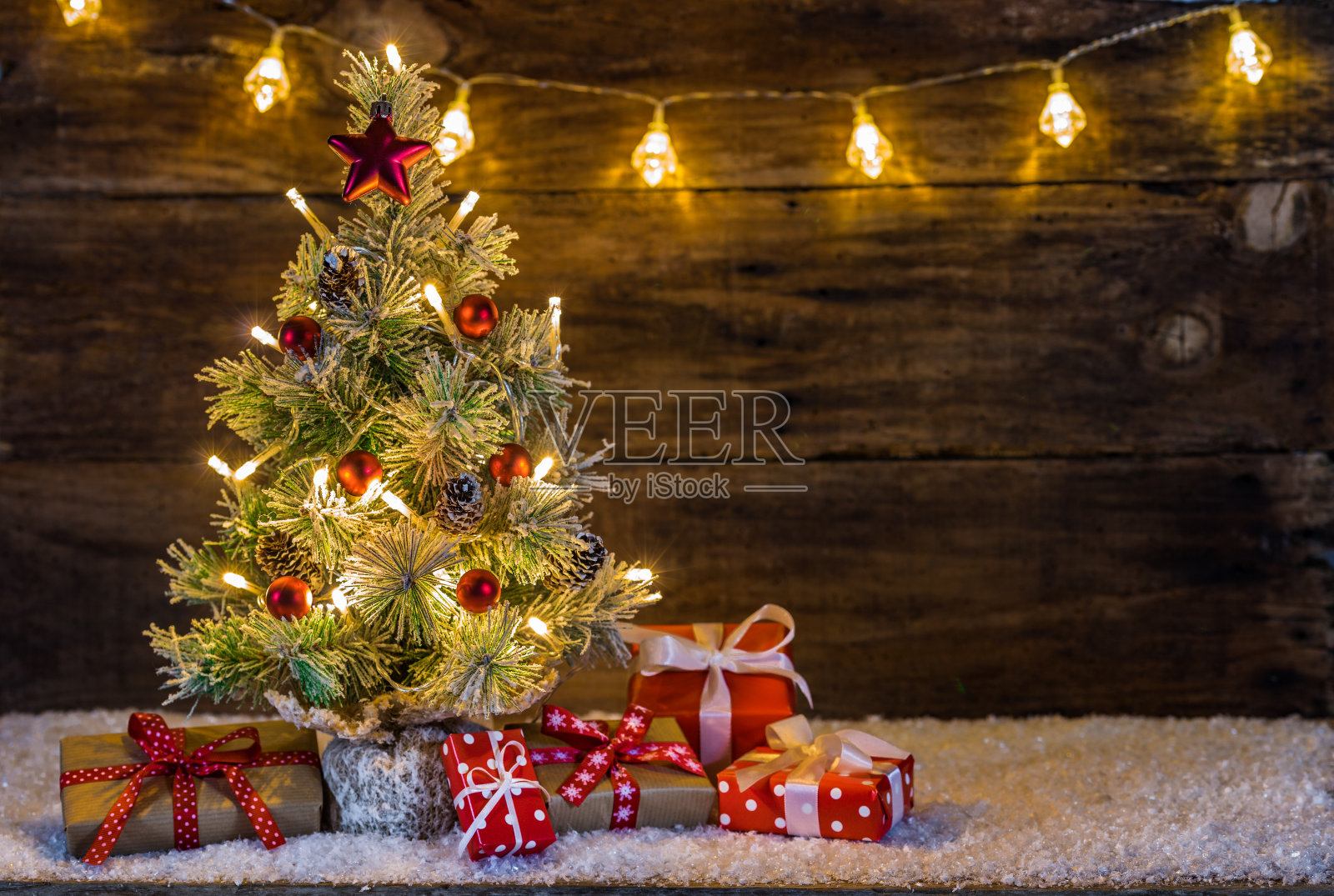装饰着节日彩灯和礼盒的圣诞树照片摄影图片
