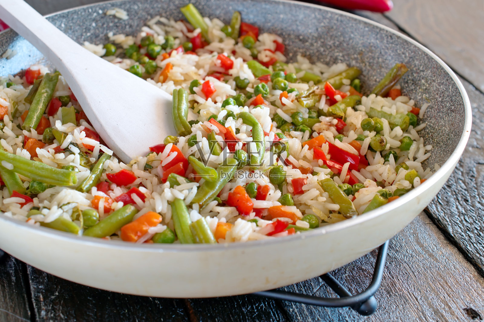 用橄榄油和蔬菜在煎锅里煮的米饭。照片摄影图片