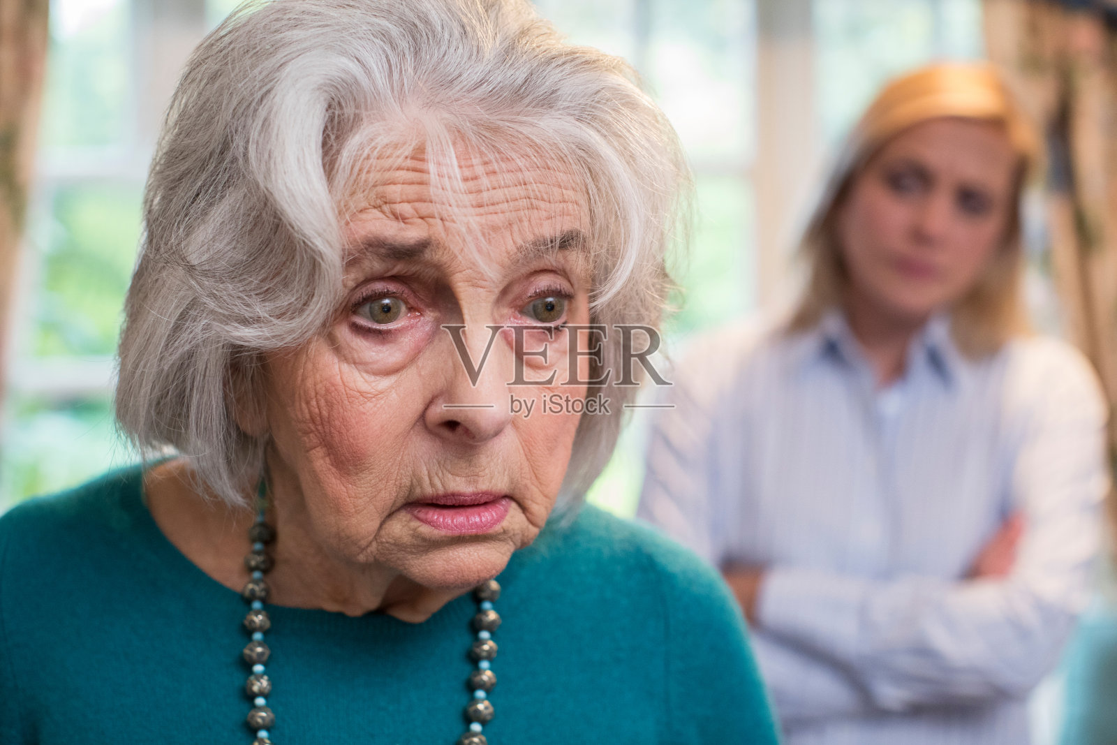 困惑的老女人和家里的成年女儿照片摄影图片