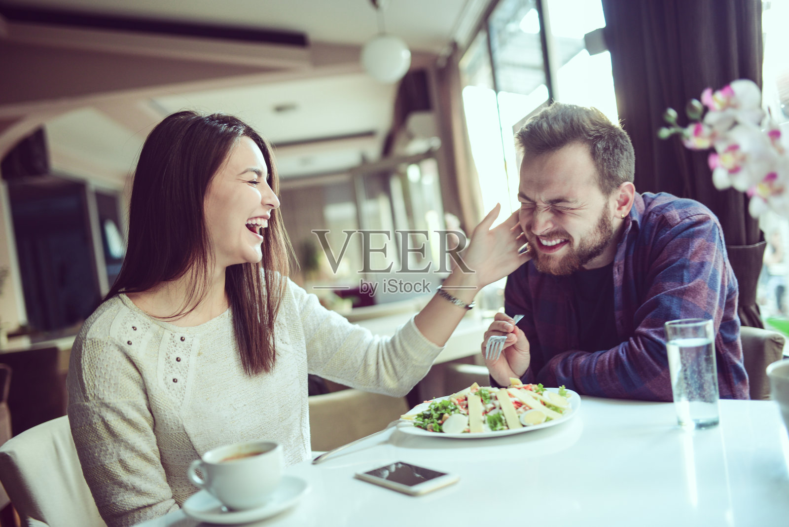 微笑女性扇男友耳光，强迫吃沙拉照片摄影图片