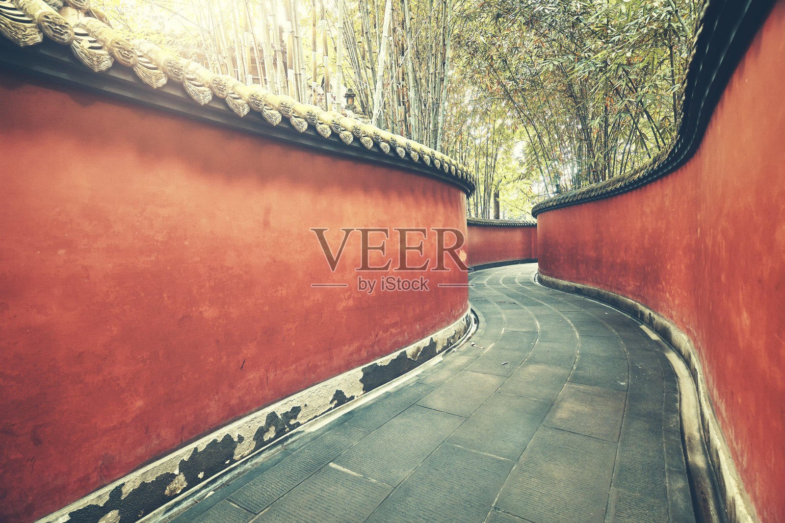弯弯曲曲的红墙，竹林环绕。照片摄影图片