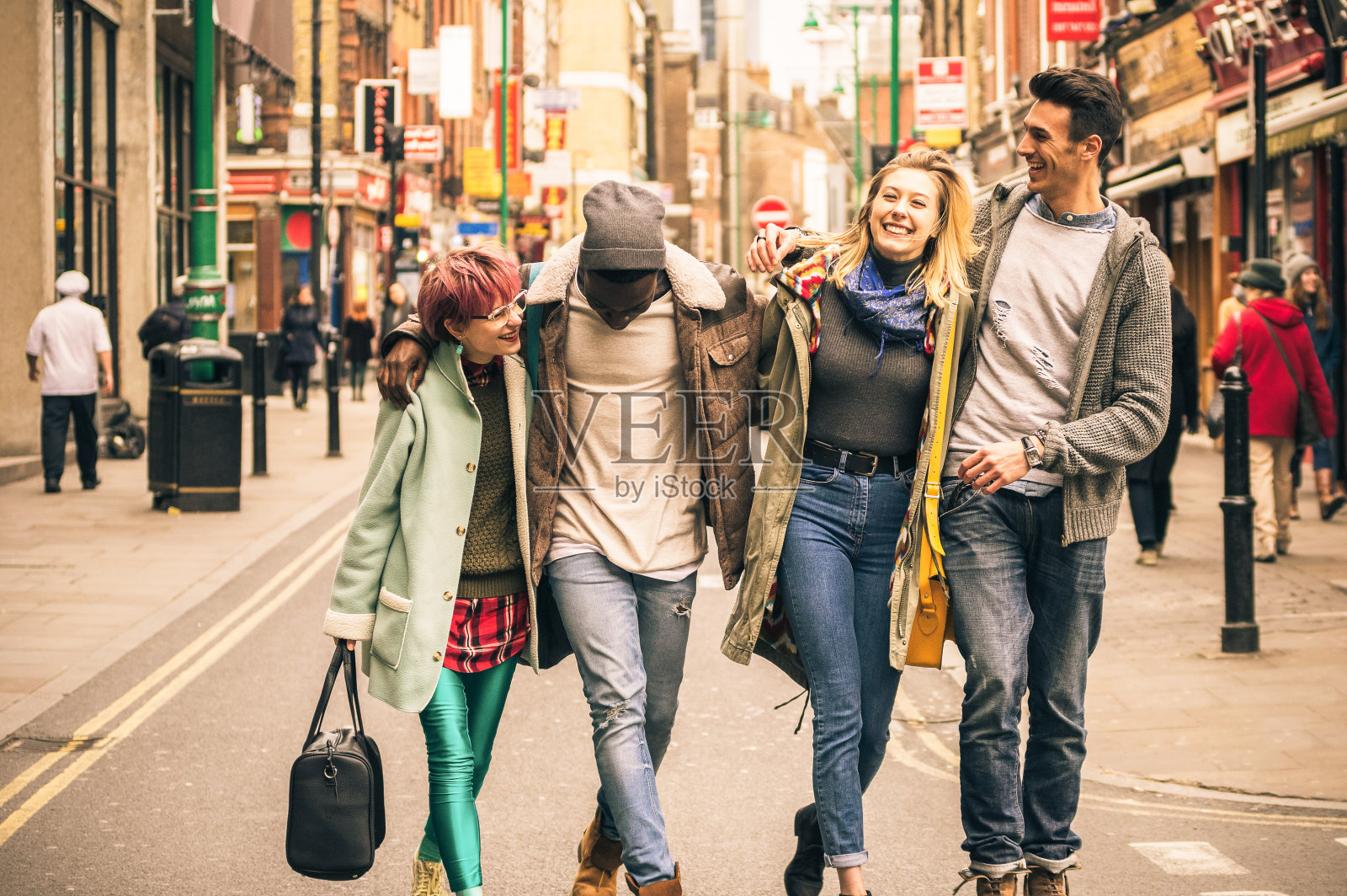 快乐的多种族的朋友走在砖巷在肖迪奇伦敦-友谊的概念与多文化的年轻人在冬天的衣服有乐趣在一起-柔软的焦点与温暖的对比过滤器照片摄影图片