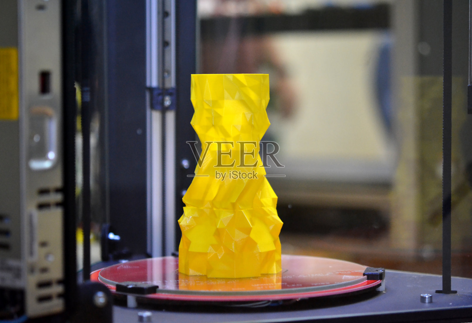 桌面上的3d打印机上放着一个黄色花瓶照片摄影图片