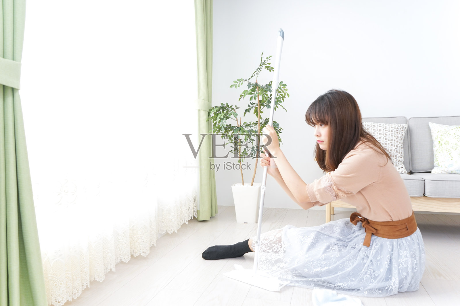年轻女子正在打扫她的房间照片摄影图片