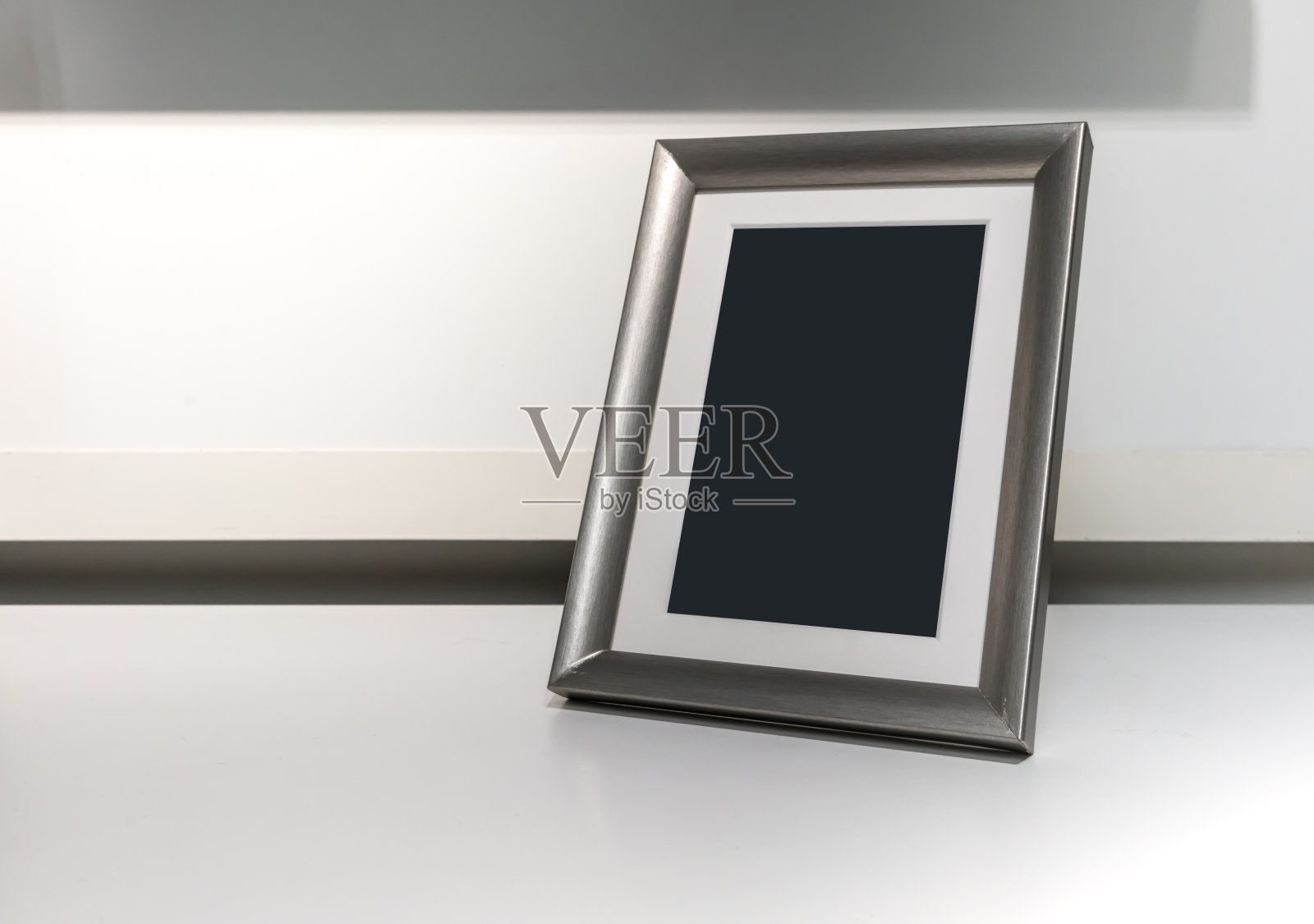 黑色空间上的垂直银色铝框架上的白色桌子照片摄影图片