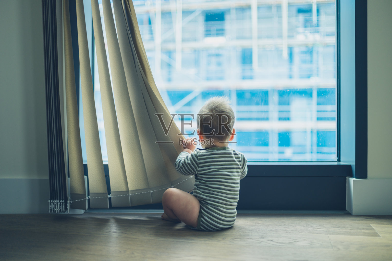 小婴儿在公寓里玩窗帘照片摄影图片